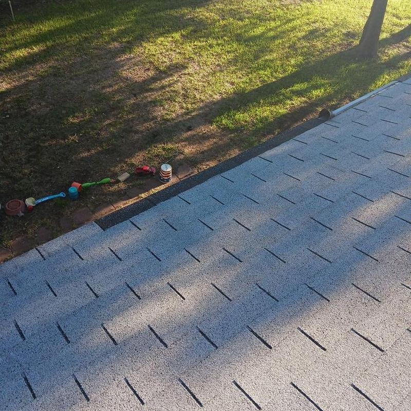 Roof shingles inspection with nearby grassy yard and toys