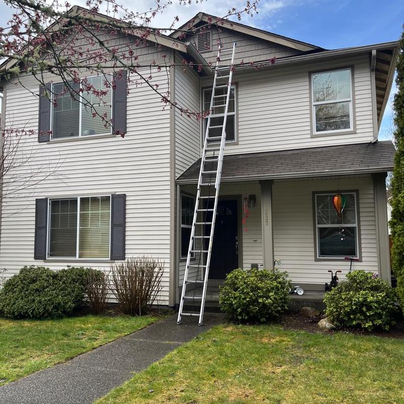 Roof shingles with wind damage and ladder setup