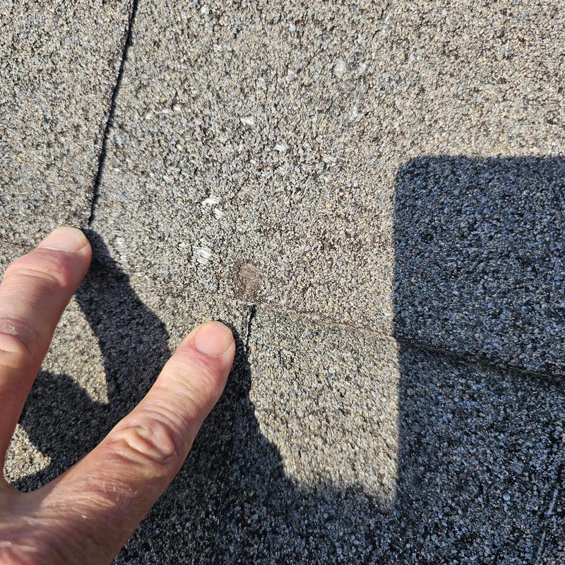 Asphalt roof shingle with hail damage close-up