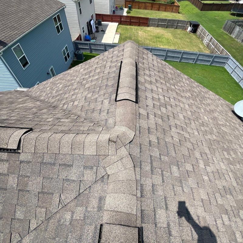 Asphalt shingle roof with ridge vents and hail damage