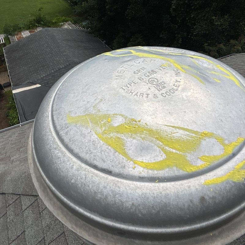 Metal roofing vent cap with yellow marking on roof