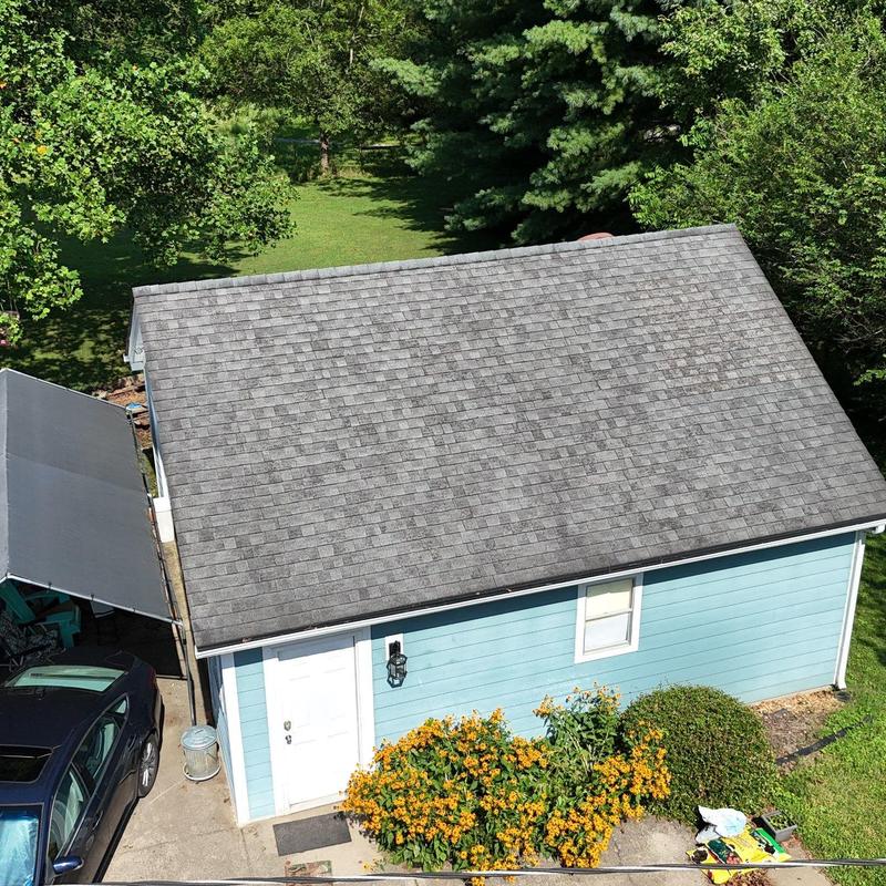 Asphalt shingle roof with slight wear and damage visible