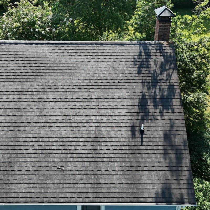 Asphalt shingle roof with hail damage and chimney