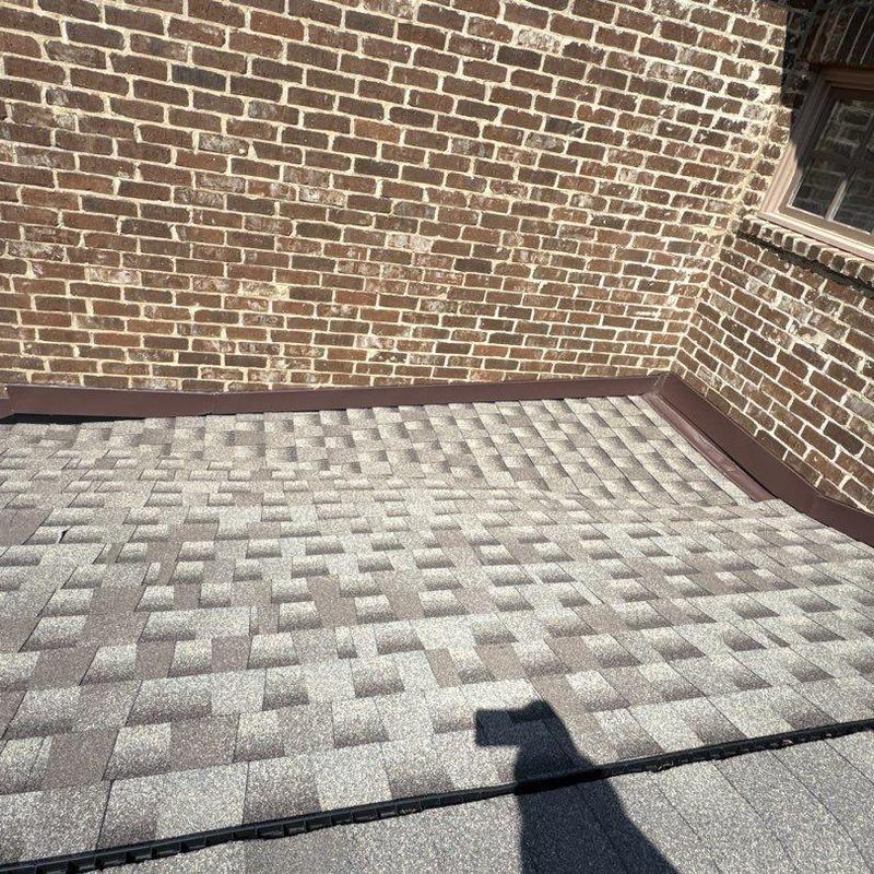 Asphalt shingle roof with flashing in brick corner