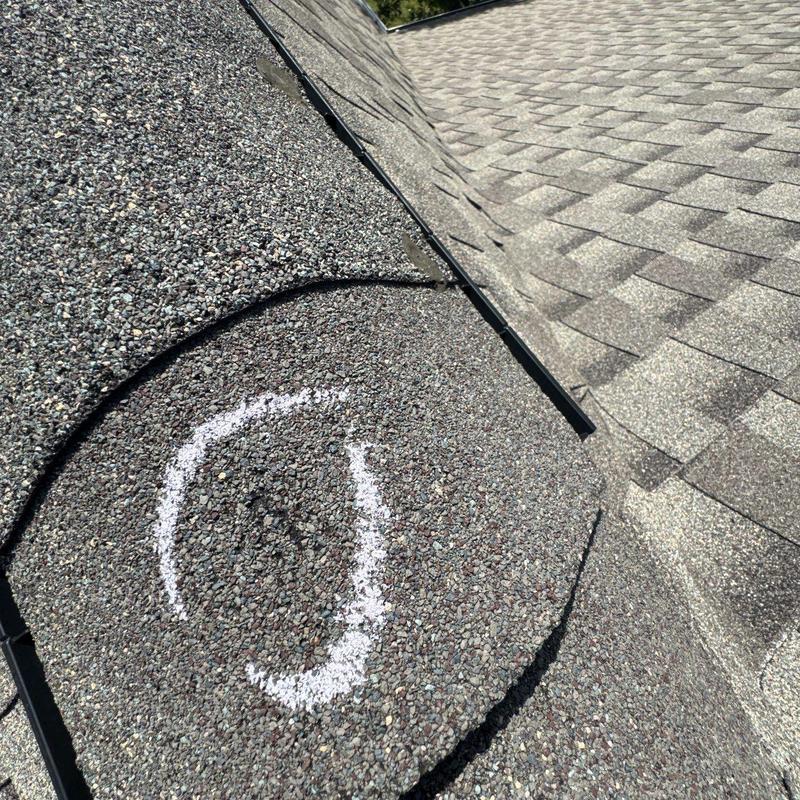 Asphalt shingle roof hail damage marked for repair
