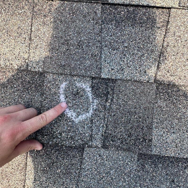 Roof shingles with hail damage marked for repair