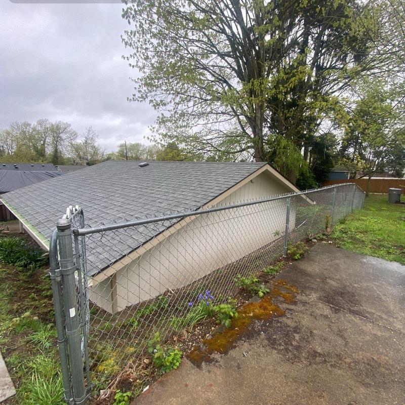 Asphalt shingle roof with clear gutters and surrounding fence Asphalt shingle roof with clear gutters and surrounding fence