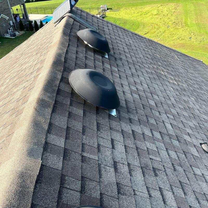 Asphalt shingle roof with ventilation caps and ridge vent