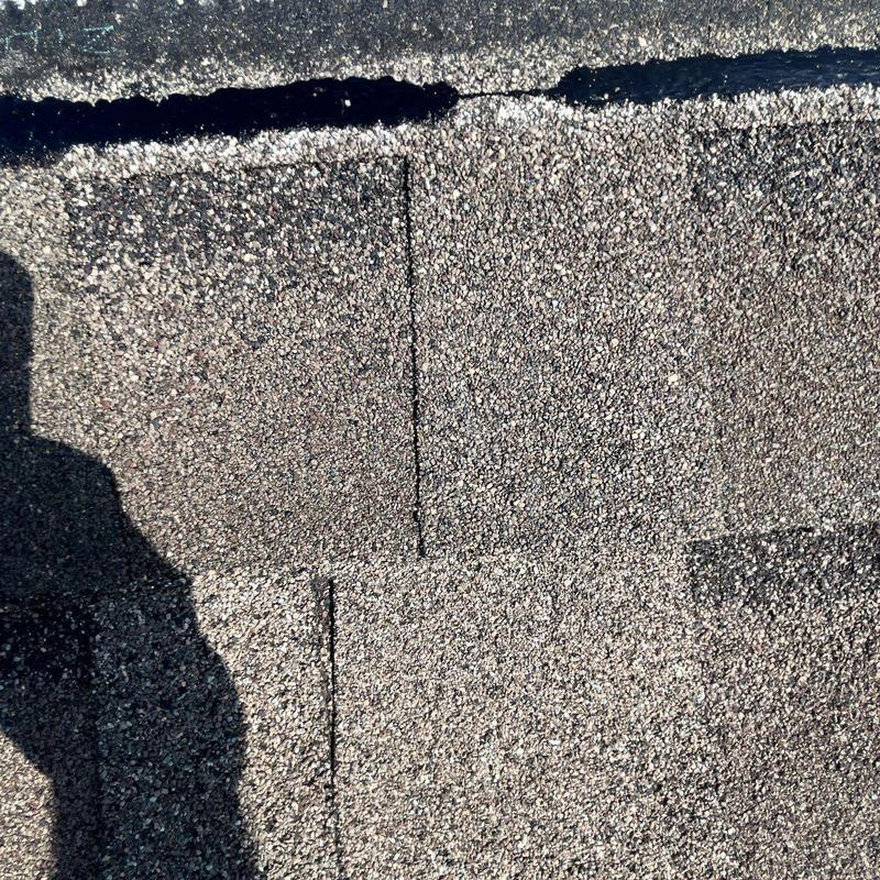 Asphalt shingles roof with hail damage and cracked sealing