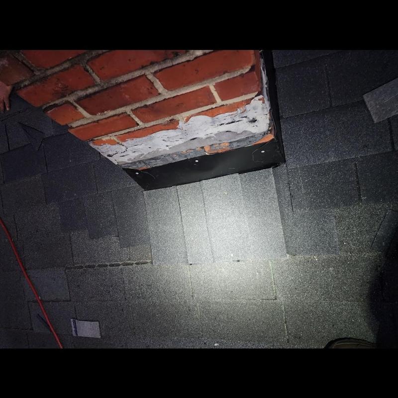 Roof shingles near chimney flashing and brickwork