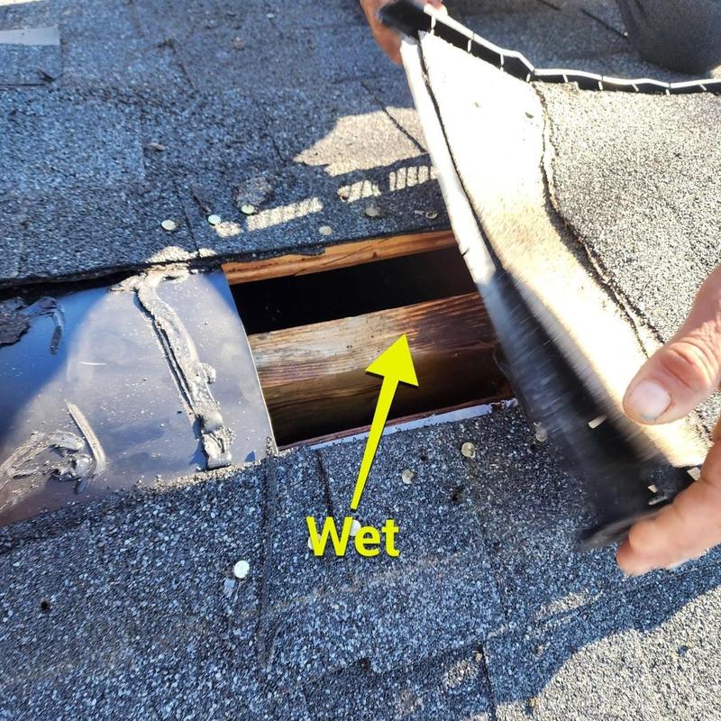 Roof shingles lifted to show wet wood underneath