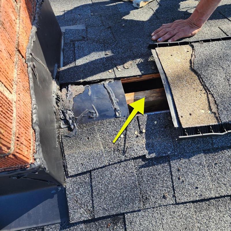 Chimney flashing with exposed roof decking and shingles