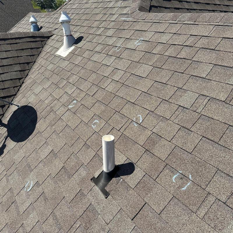 Asphalt shingle roof with marked hail damage spots