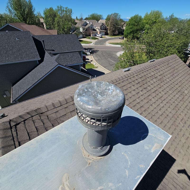 Roof vent cap with hail damage on shingle roof