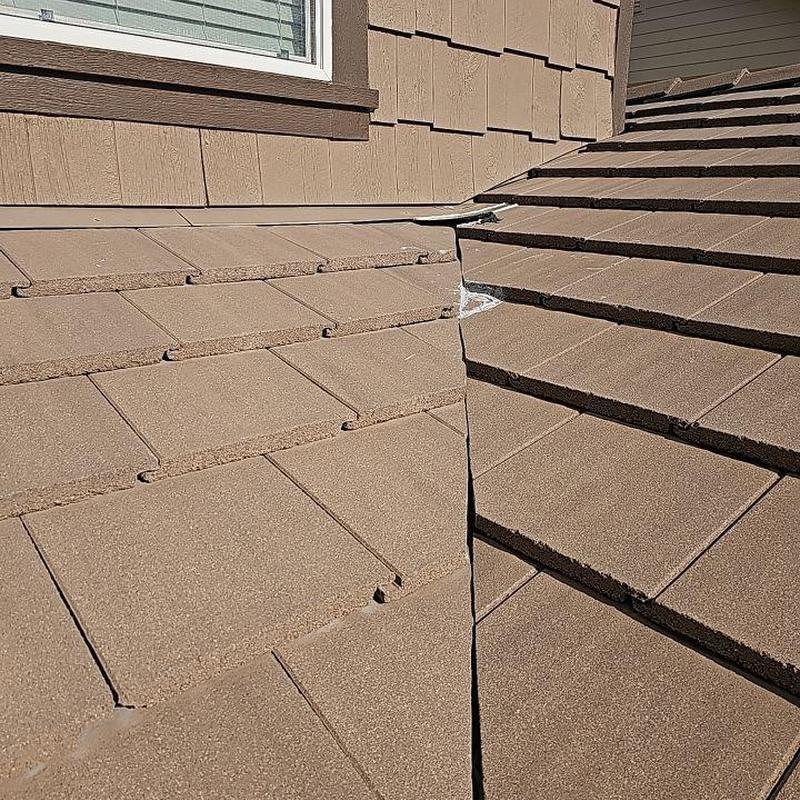 Tile roof valley with visible sealant and joint gap