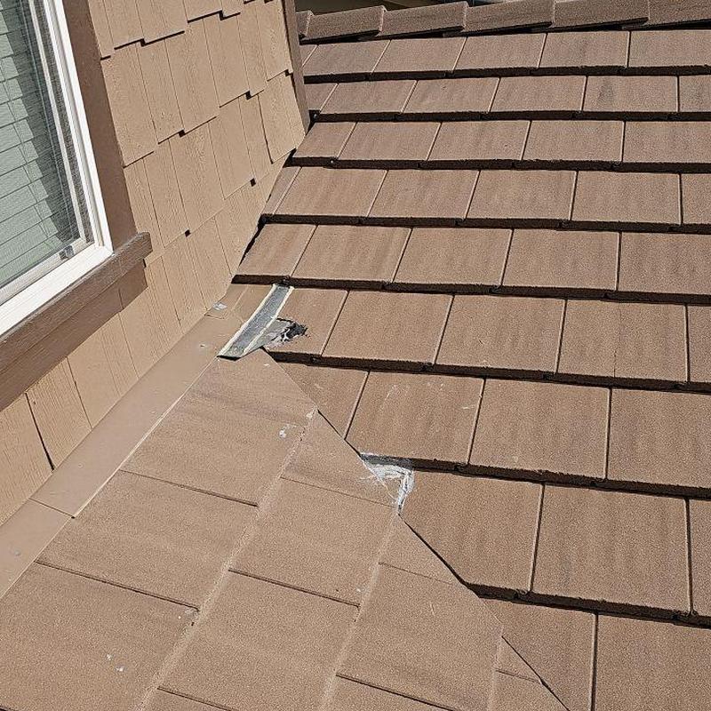 Tile roof valley with damaged flashing and tiles