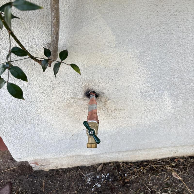 Outdoor hose bib with shutoff valve on stucco wall