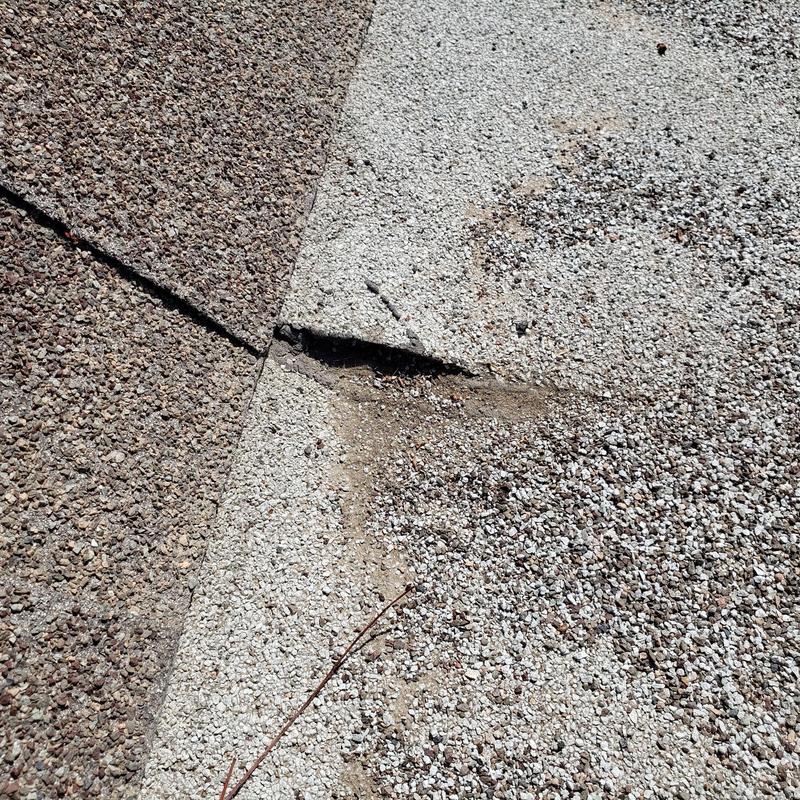 Shingle roof with damaged granules and torn edge