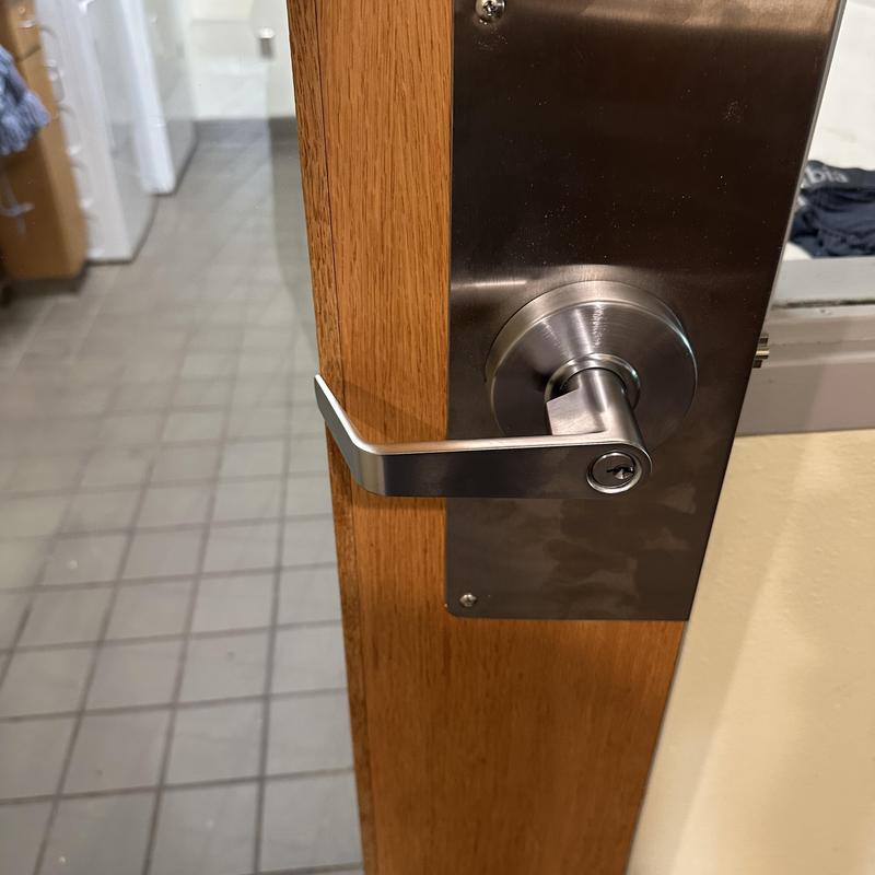 Commercial lever lock with metal wrap on wooden door