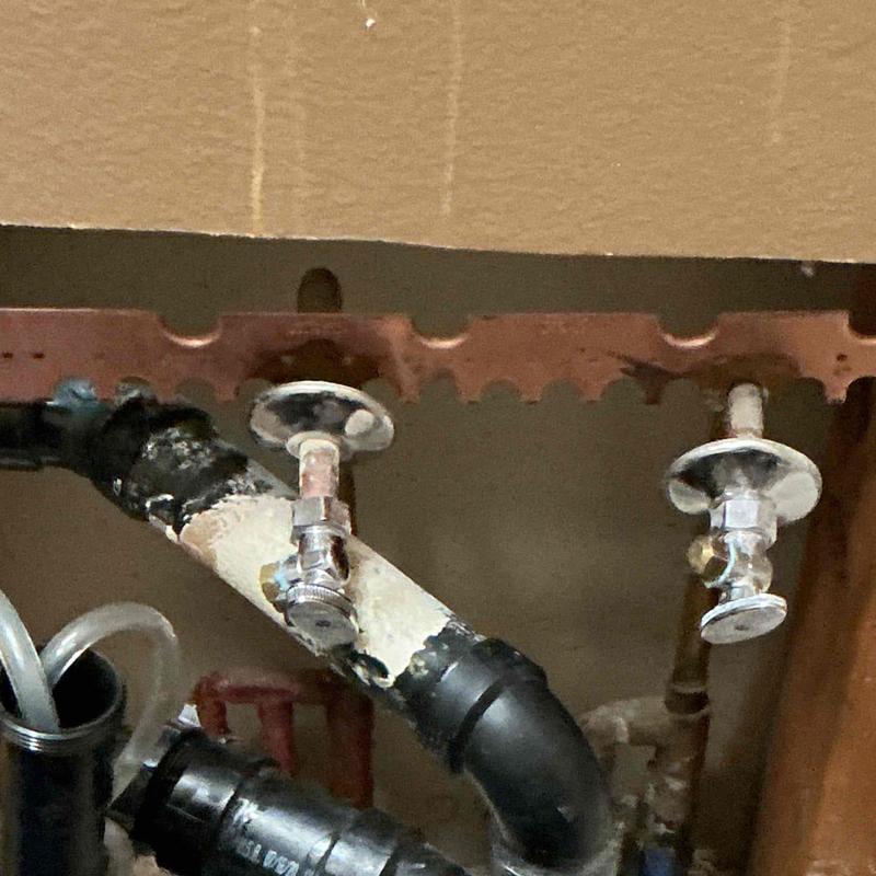 Angle stop valves on water supply pipes under sink