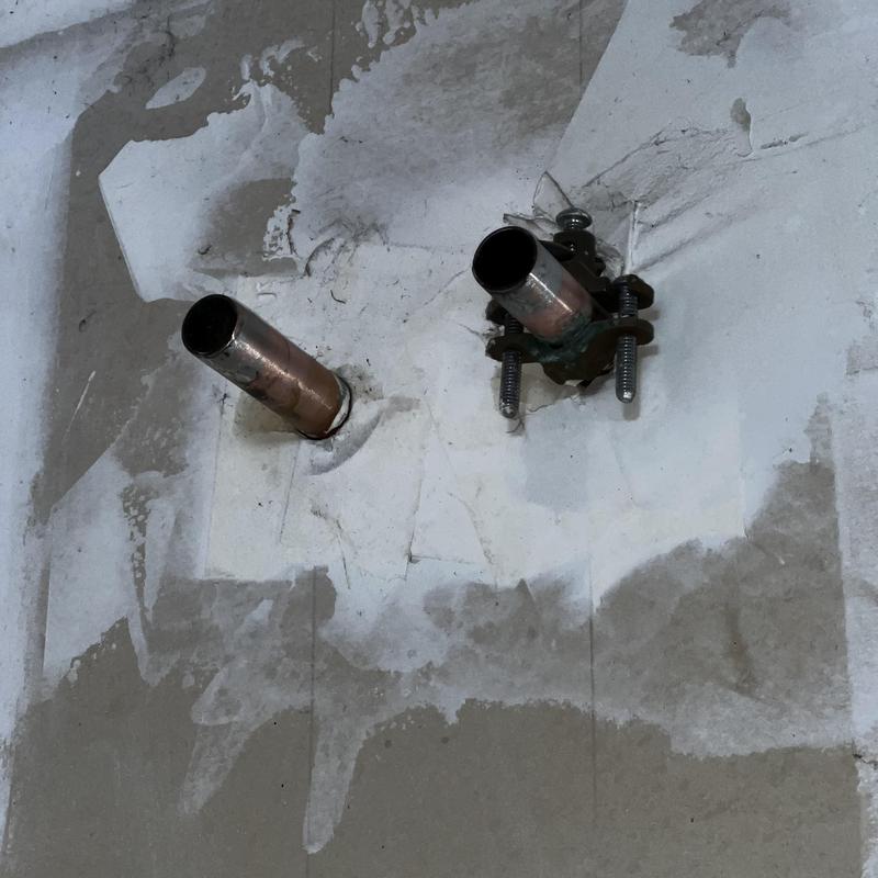 Water heater pipe connections on wall surface