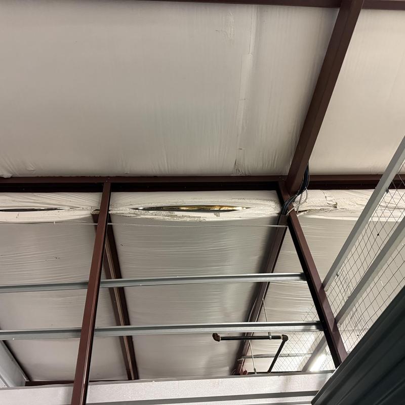 Commercial roof insulation with visible damage and framing