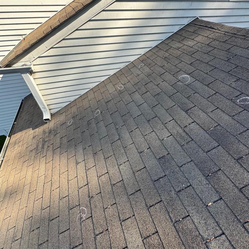 Asphalt shingle roof with marked hail damage spots