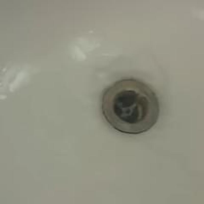 Tub drain with water clearing clog in bathtub basin