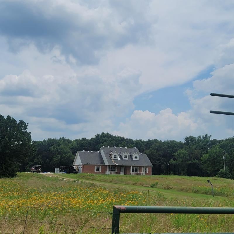Roof shingles with hail damage on rural house