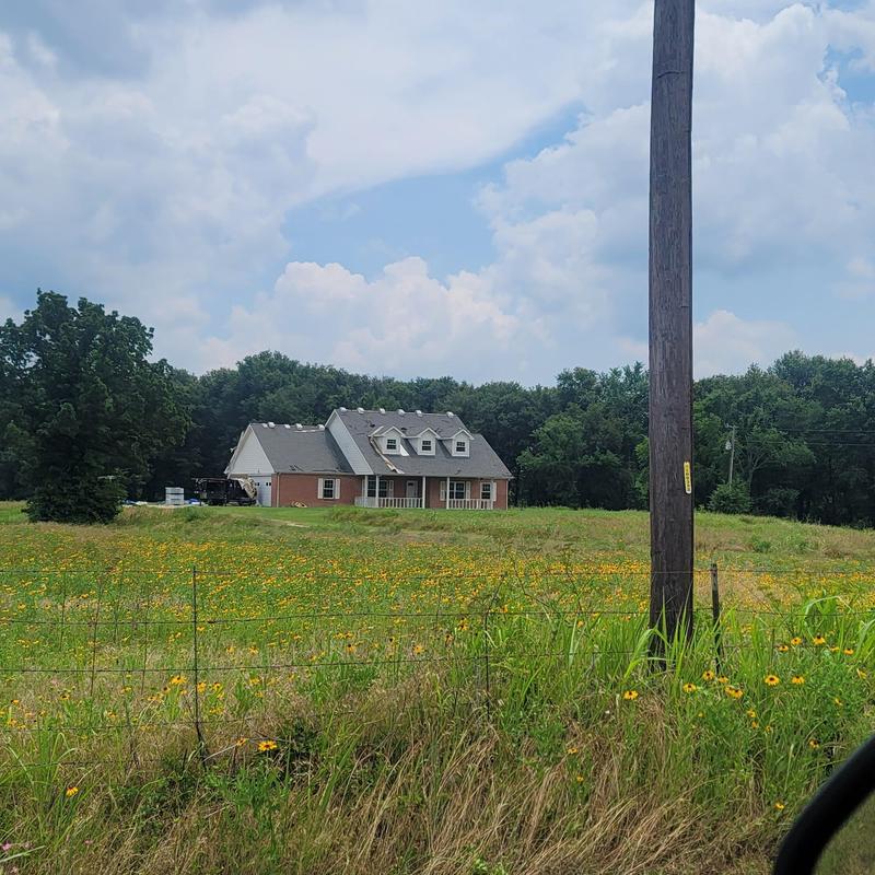 Roof shingles with hail damage on rural house