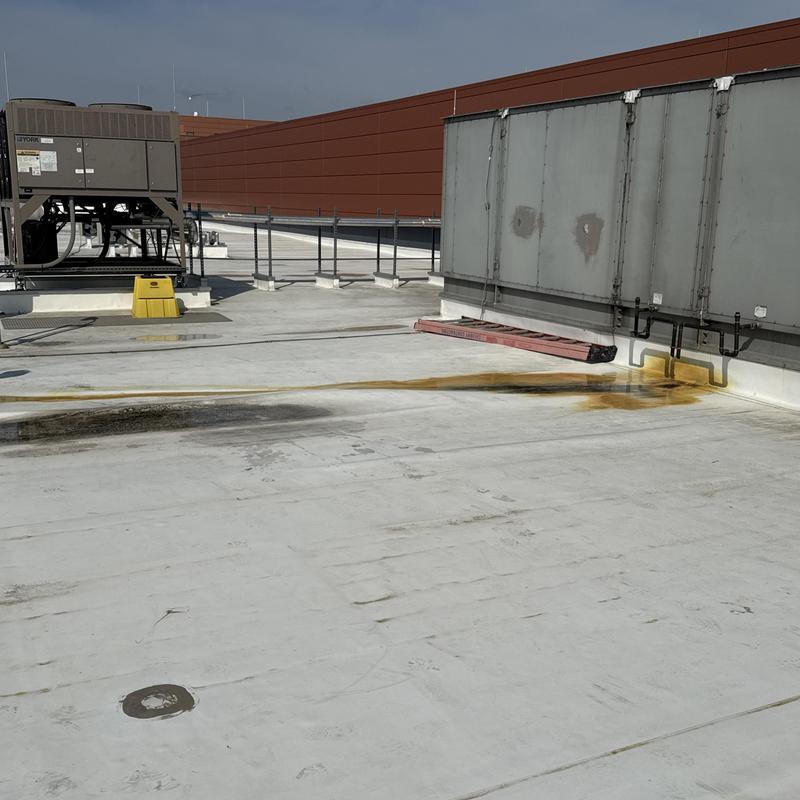 TPO flat roof with rust stains near HVAC units