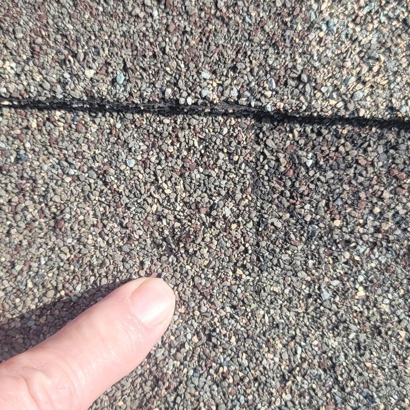 Asphalt roof shingle with hail damage close-up