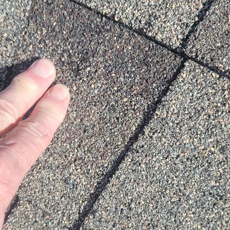Asphalt roof shingles with hail damage close-up