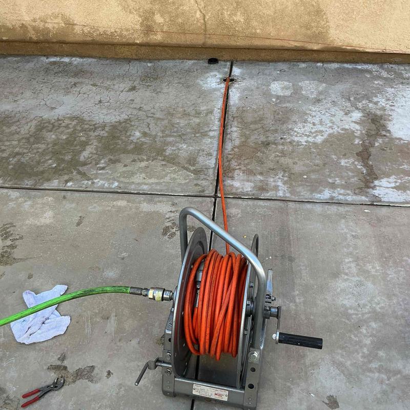 Sewer drain hydro jetting hose reel on driveway