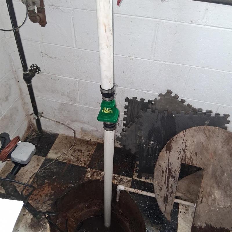 Sump pump discharge pipe with backflow valve installation