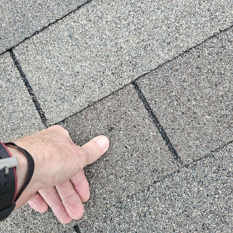 Roof shingles with hail damage close-up inspection