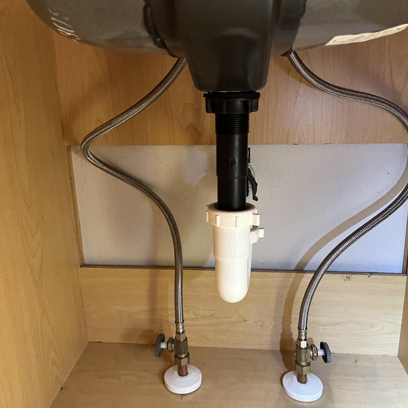 Braided supply lines and sink drain assembly under cabinet