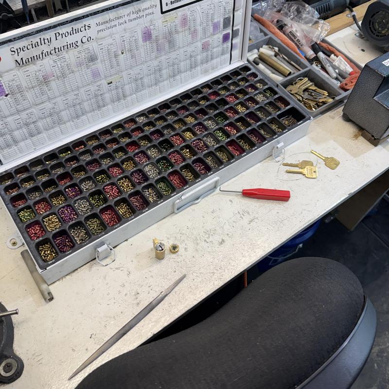 Lock tumbler pins sorting tray with tools on workbench