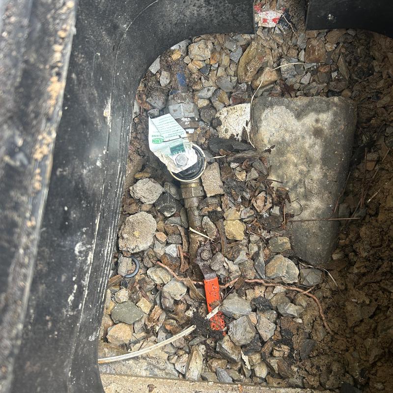 Water pressure regulator in gravel pit with valve tag Water pressure regulator in gravel pit with valve tag