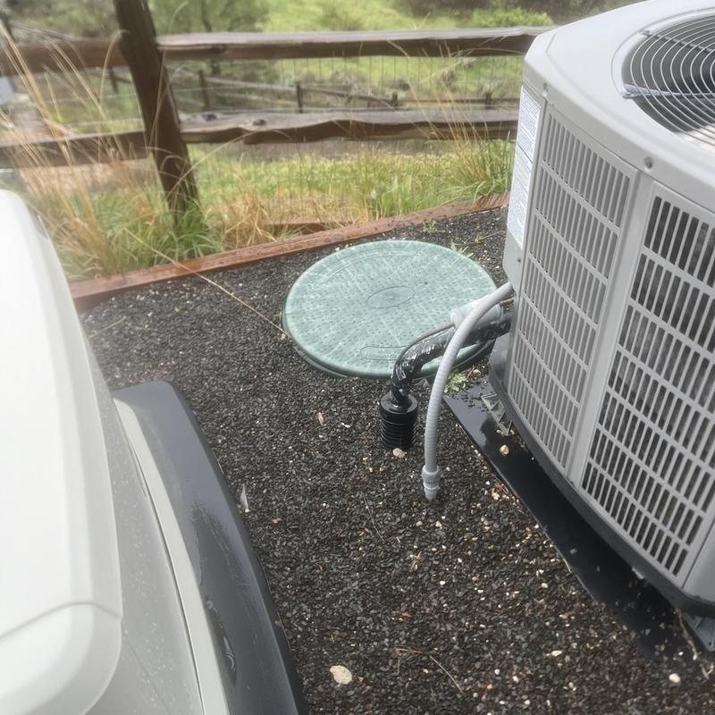 Septic tank cover near air conditioning unit outdoors