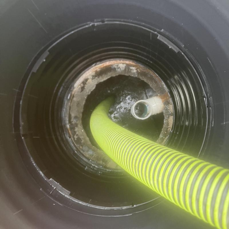 Septic tank interior with yellow pump-out hose inserted