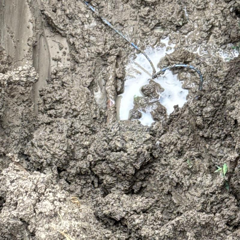 Copper water service line leak excavation in muddy soil
