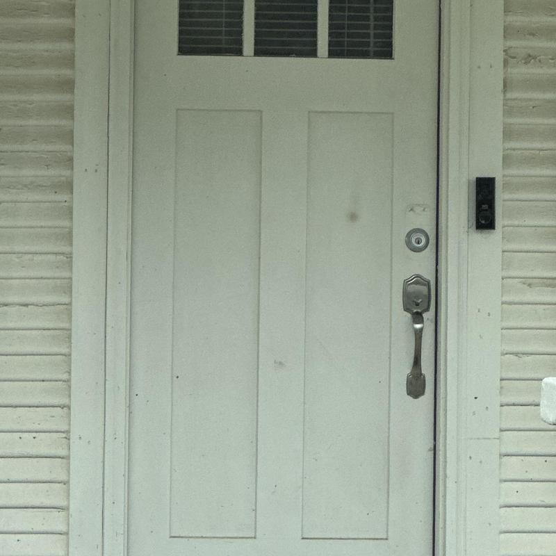 Deadbolt lock on white exterior door with keypad removed