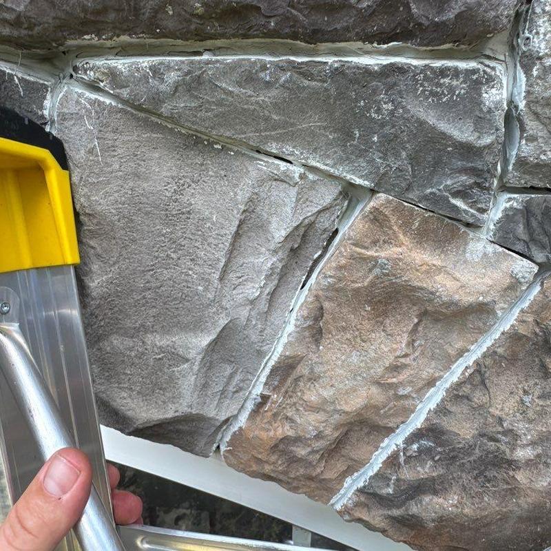 Stone veneer wall with cracked mortar and sealant repairs
