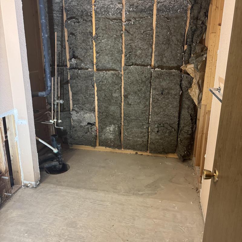 Bathroom plumbing and framing exposed for shower install
