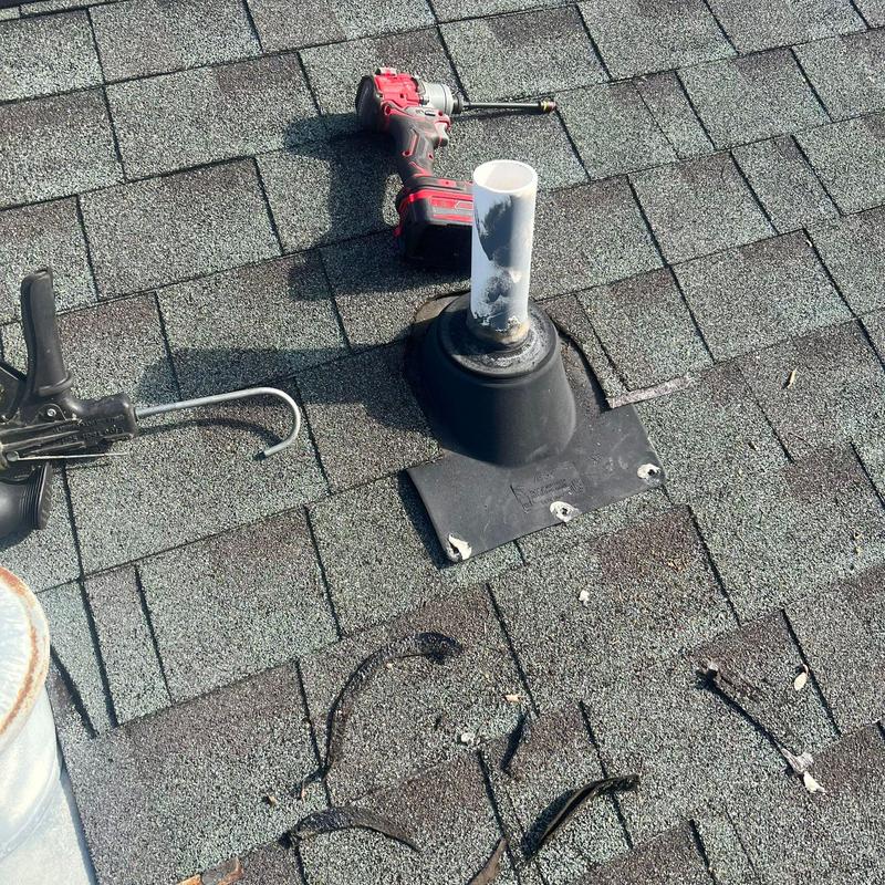 Roof pipe flashing with damaged shingles and repair tools