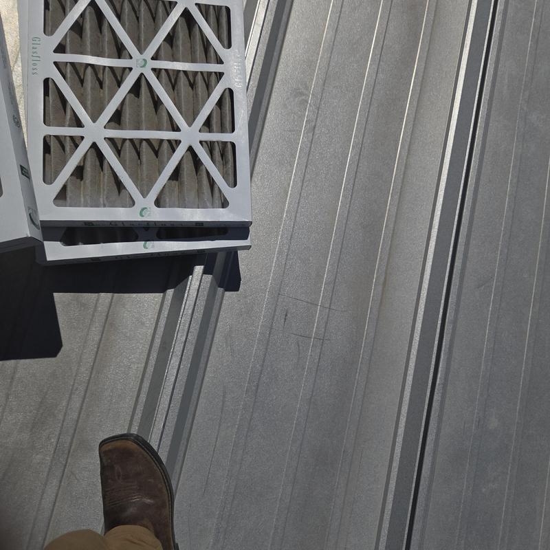 HVAC air filters on metal roof surface with boot visible