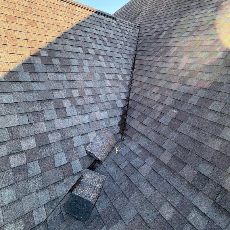 Roof shingles with hail damage and lifted tiles