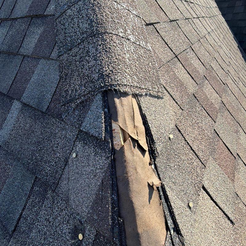 Roof shingles with lifted and damaged ridge cap shingles