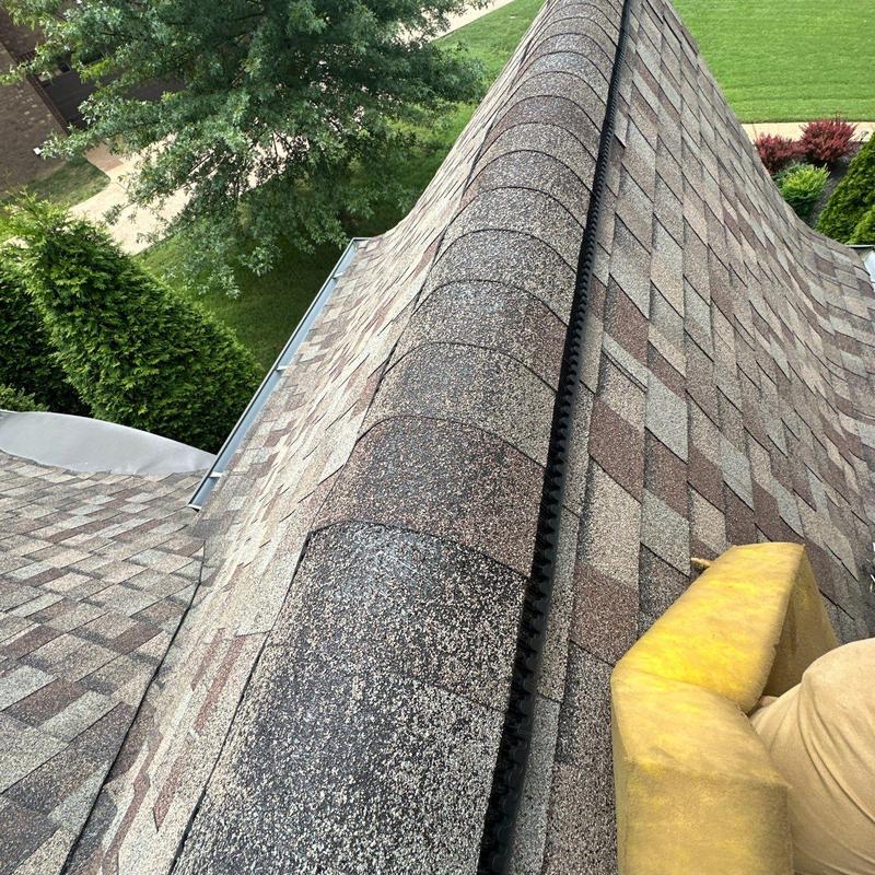 Asphalt shingle roof ridge with hail damage inspection